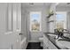 Modern bathroom with double vanity, black countertop, and window overlooking the yard at 5313 Wenesly Ct, Raleigh, NC 27616