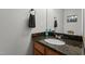 Powder room with dark granite countertop, undermount sink, towel ring, and decorative accents at 5313 Wenesly Ct, Raleigh, NC 27616