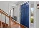 Inviting foyer featuring hardwood floors, a vibrant blue front door with sidelights, and a staircase at 5313 Wenesly Ct, Raleigh, NC 27616