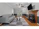 Cozy living room with a fireplace, ceiling fan, hardwood floors, and French doors to the deck at 5313 Wenesly Ct, Raleigh, NC 27616