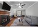 Comfortable living room featuring a fireplace, ceiling fan, hardwood floors, and a large window at 5313 Wenesly Ct, Raleigh, NC 27616