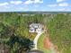 Aerial view of home surrounded by trees, with long driveway at 56 Mist Wood Ct, Pittsboro, NC 27312