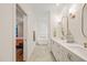Bright bathroom featuring double sinks, white cabinetry, and a luxurious soaking tub at 56 Mist Wood Ct, Pittsboro, NC 27312