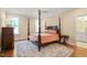 Spacious bedroom with a four-poster bed, decorative rug, and abundant natural light at 56 Mist Wood Ct, Pittsboro, NC 27312
