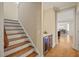 Hallway featuring hardwood floors and stairway leading to bar area with custom built-in cabinets at 56 Mist Wood Ct, Pittsboro, NC 27312