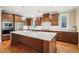 Spacious kitchen features an island with quartz countertops, stainless appliances, and hardwood floors at 56 Mist Wood Ct, Pittsboro, NC 27312