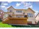 Expansive backyard view featuring a raised deck and lush green lawn beneath a partly cloudy sky at 5624 Bennettwood Ct, Raleigh, NC 27612
