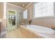 Elegant bathroom featuring a soaking tub, glass shower, and a spacious walk-in closet at 5624 Bennettwood Ct, Raleigh, NC 27612