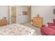 Bright bedroom featuring a patterned bedspread, wooden dresser, and neutral walls with staircase access at 5624 Bennettwood Ct, Raleigh, NC 27612
