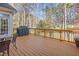 Outdoor deck with dark wicker chairs, a stone table, and a covered grill, perfect for entertaining at 5624 Bennettwood Ct, Raleigh, NC 27612