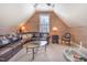 This living room has a large brown leather sofa, lots of light, and a dog bed at 5624 Bennettwood Ct, Raleigh, NC 27612