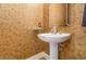 Charming powder room featuring unique wallpaper and a pedestal sink at 5624 Bennettwood Ct, Raleigh, NC 27612