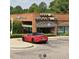 Exterior of Harmony Farms Natural Foods with red sports car parked in front, highlighting local shopping convenience at 5624 Bennettwood Ct, Raleigh, NC 27612