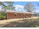 A view of the backyard with a brick house and a well-maintained lawn at 5630 Jones Sausage Rd, Garner, NC 27529