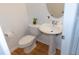 Powder room featuring a pedestal sink, decorative mirror, and modern fixtures, ideal for guests at 603 Mountain Pine Dr, Cary, NC 27519