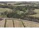Panoramic aerial view of farmland and woods, with a property nestled in the center at 610 Flemingtown Rd, Henderson, NC 27537