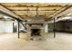 Unfinished basement with brick fireplace, exposed ceiling beams and ductwork at 610 Flemingtown Rd, Henderson, NC 27537