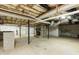 Unfinished basement with brick fireplace, concrete floor, and exposed ceiling beams at 610 Flemingtown Rd, Henderson, NC 27537