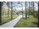 Long driveway leading to a single Gathering home nestled among lush, mature trees at 610 Flemingtown Rd, Henderson, NC 27537
