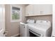 Bright laundry room featuring a washer and dryer with white cabinets at 610 Flemingtown Rd, Henderson, NC 27537