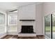 Bright living room featuring a white brick fireplace with a black firebox and hardwood floors at 610 Flemingtown Rd, Henderson, NC 27537
