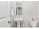 Cozy half-bath features a pedestal sink, white fixtures, and a decorative mirror at 709 Conifer Ct, Creedmoor, NC 27522