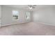 Sunlit bedroom with neutral carpet, two large windows, and a ceiling fan at 709 Conifer Ct, Creedmoor, NC 27522