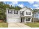 Charming two-story home features a two-car garage and classic black shutters set against a backdrop of lush, mature trees at 709 Conifer Ct, Creedmoor, NC 27522