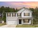 Charming two-story home features a two-car garage and classic black shutters set against a backdrop of lush, mature trees at 709 Conifer Ct, Creedmoor, NC 27522