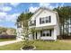 Charming two-story home features a two-car garage and classic black shutters set against a backdrop of lush, mature trees at 709 Conifer Ct, Creedmoor, NC 27522
