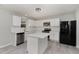 Modern kitchen featuring white cabinets, stainless steel appliances, quartz countertops, and an island perfect for entertaining at 709 Conifer Ct, Creedmoor, NC 27522