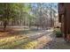 Spacious backyard with scattered trees and a gravel path, perfect for outdoor activities at 735 Jordan Hills Loop, Chapel Hill, NC 27517