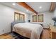 Bright bedroom featuring hardwood floors, exposed beam, and multiple windows framing wooded views at 735 Jordan Hills Loop, Chapel Hill, NC 27517