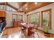 Dining room area with wood ceiling, hardwood floors, glass-top dining table and beautiful wooded view from windows at 735 Jordan Hills Loop, Chapel Hill, NC 27517