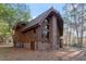 Rustic two-story house featuring wood siding, a brick foundation, and an attached deck at 735 Jordan Hills Loop, Chapel Hill, NC 27517