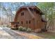 Two-story house displaying wood cladding, a brick foundation, and a charming deck at 735 Jordan Hills Loop, Chapel Hill, NC 27517