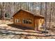 View of building featuring a brick foundation, row of windows, set among tall trees and offering a private setting at 735 Jordan Hills Loop, Chapel Hill, NC 27517