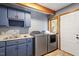 Well-lit laundry room featuring blue cabinets, sink, and modern washer and dryer at 735 Jordan Hills Loop, Chapel Hill, NC 27517