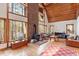 Inviting living room with wood burning fireplace, wood ceiling, hardwood floors and large windows showing wooded property at 735 Jordan Hills Loop, Chapel Hill, NC 27517
