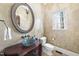 Stylish powder room featuring a unique glass bowl sink, textured walls, and a decorative oval mirror at 7504 Everton Way, Wake Forest, NC 27587