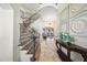 Elegant foyer with grand staircase, tile floors, and ornate wall decor leads into a dining and living area at 7504 Everton Way, Wake Forest, NC 27587