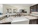 View of the kitchen island with granite countertops, white farmhouse sink, and views to the outdoor living area at 7504 Everton Way, Wake Forest, NC 27587