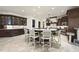 Spacious kitchen featuring dark wood cabinets, large island with seating, and tile flooring at 7504 Everton Way, Wake Forest, NC 27587