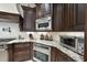 Close-up of kitchen with dark wood cabinets, granite countertops, and stainless steel appliances at 7504 Everton Way, Wake Forest, NC 27587