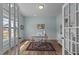 Bright office with a desk, chair, and charming decor, bathed in natural light through French doors at 80 Westbrook Ln, Franklinton, NC 27525