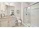 Bright bathroom features vanity with granite counters, decorative mirror and a glass-enclosed shower at 804 Cambridge Hall Loop, Apex, NC 27539