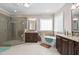 Elegant bathroom featuring a soaking tub, glass shower, and granite countertops at 804 Cambridge Hall Loop, Apex, NC 27539