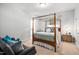 Inviting bedroom with a canopy bed, sitting area, and a doorway to the bathroom at 804 Cambridge Hall Loop, Apex, NC 27539