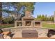 Outdoor stone fireplace with built-in storage and seating area, perfect for entertaining at 804 Cambridge Hall Loop, Apex, NC 27539