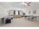 A large recreation room with ping pong, air hockey table, sofa, media center, and ceiling fan at 804 Cambridge Hall Loop, Apex, NC 27539